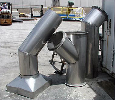 Custom fabricated stainless steel ductwork elbows and fittings in the yard